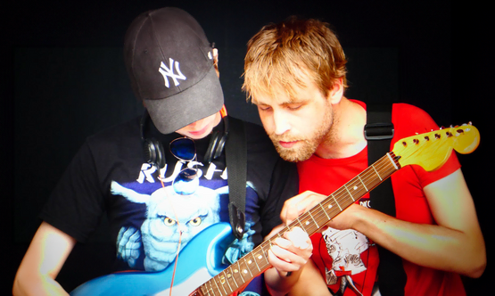 mann lærer en gutt å spille gitar
